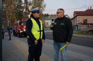 Policjantka z drogówki udziela wywiadu radiowego.