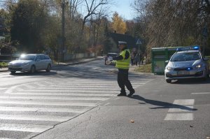 Policjant kieruje ruchem w rejonie skrzyżowania.