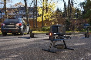 Policyjny bezzałogowy statek powietrzny - dron stoi na parkingu.