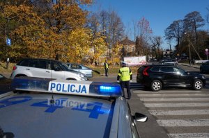 Policjant kieruje ruchem w rejonie skrzyżowania.