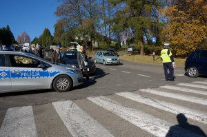 Policjant kieruje ruchem w rejonie skrzyżowania.