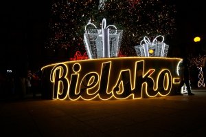 Podświetlany napis BIELSKO na podstawie choinki miejskiej bożonarodzeniowej. Zdjęcie wykonane po zmierzchu.