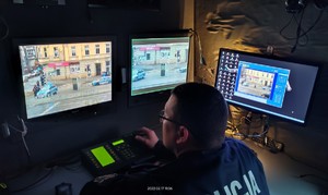 Policjant ruchu drogowego obserwuje monitory komputerów w specjalnym radiowozie