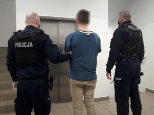 Policjanci prowadzą zatrzymanego mężczyznę