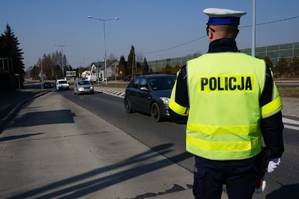 Policjant z ruchu drogowego obserwuje pojazdy