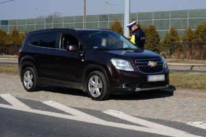 Policjant ruchu drogowego kontroluje kierowcę osobowego samochodu