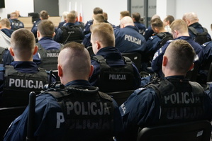 Policjanci siedzą na sali odpraw.