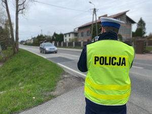 Policjant ruchu drogowego mierzy prędkość nadjeżdżających pojazdów