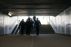 Policjanci idą przejściem podziemnym na dworcu kolejowym
