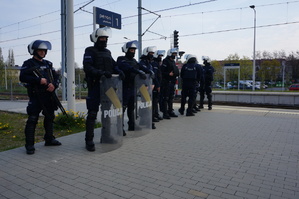 Policjanci z oddziału prewencji stoją w rzędzie na peronie kolejowym