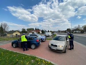 Policjanci z drogówki kontrolują pojazdy.