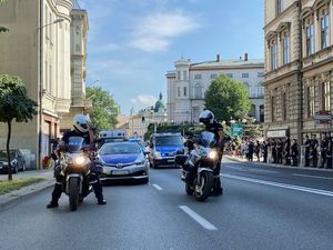 Policjanci na motocyklach stoją na jezdni.