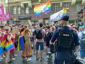 Policjant w mundurze przygląda się uczestnikom marszu.