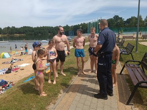 Policjant rozmawia z plażowiczami