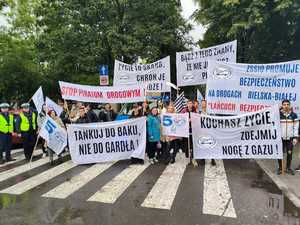 Zdjęcie przedstawia grupę osób wraz z policjantami, którzy pozują do zdjęcia. Większość z osób trzyma w reku transparent.