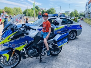 Na zdjęciu na motocyklu policyjnym  siedzi dziecko.
