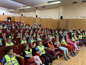 Dzieci podczas prelekcji policjanta, promują noszenie odblasków